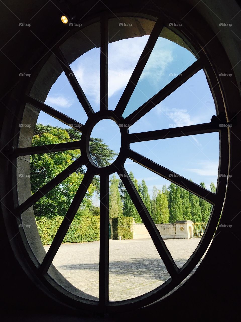 Garden park view through a round window frame 