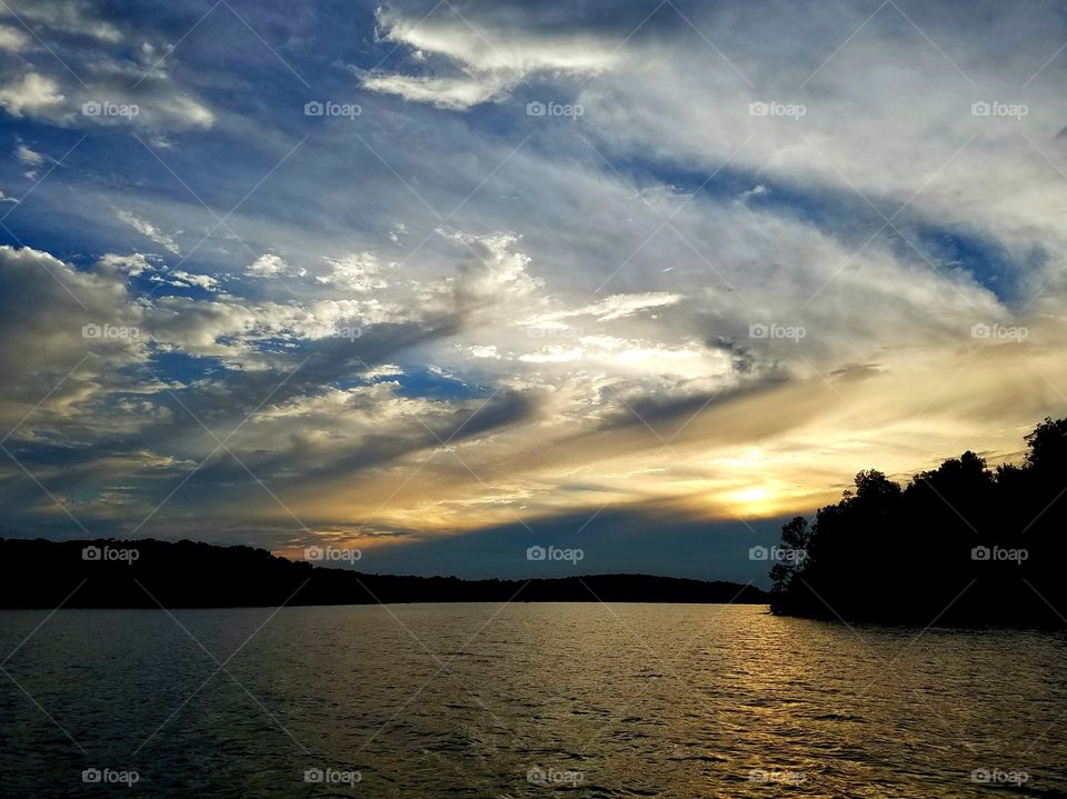 beautiful sunset with clouds over lake.