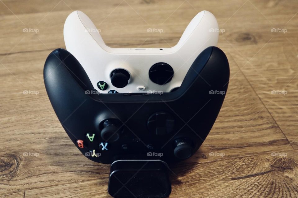 Xbox black and white controllers in charger