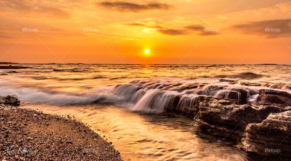 Waves over the rock during sunset