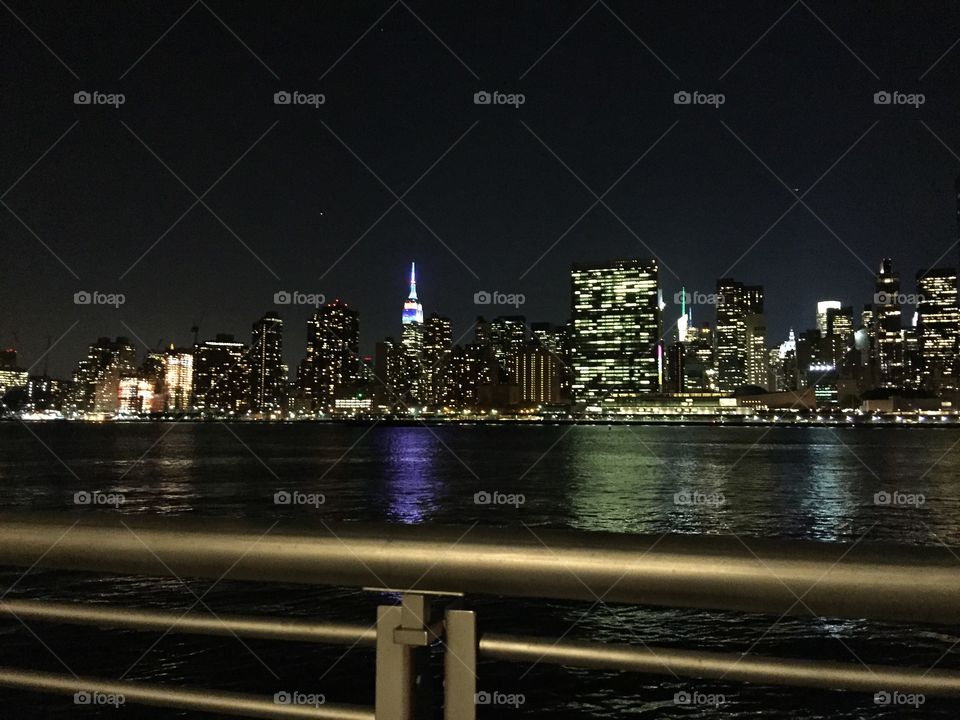 Midtown Manhattan at night. A view of the UN, Empire State Building, and Chrysler Building taken from Long Island City