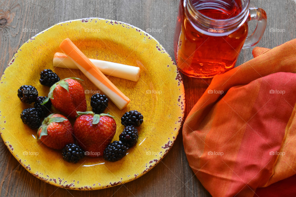 Cheese sticks and fruit with a glass of juice