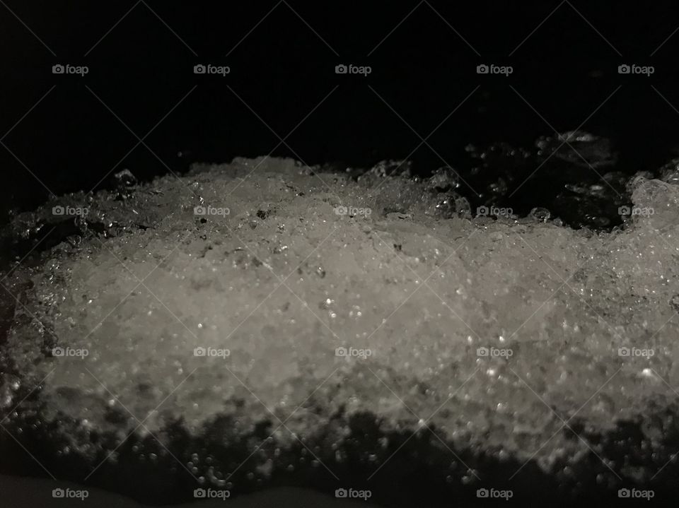 Snowy. Snow crystals shining on the roof. Close up picture of melting snow, right after snowy weather. Taken in the night.