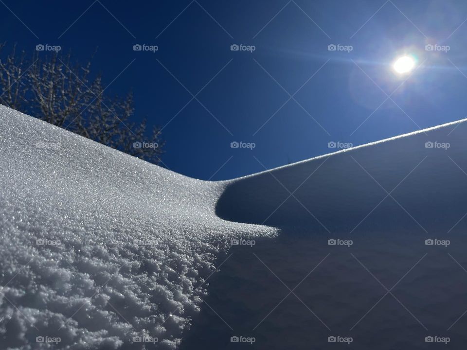 The sun shining on a snowy surface. 