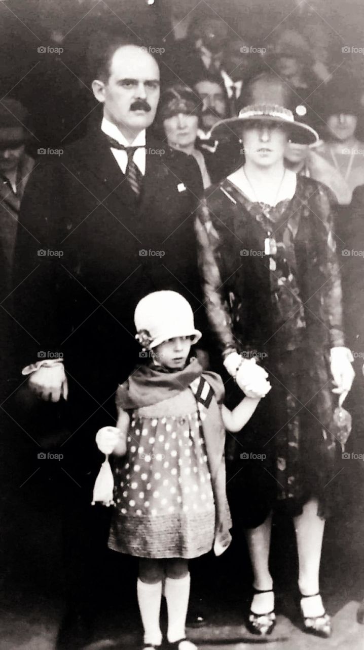 Sepia portrait shot of a couple and their daughter during an event in Paris in 1938