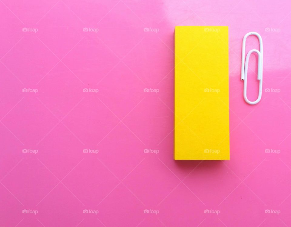 Sticky notes and paper clip with pink background...