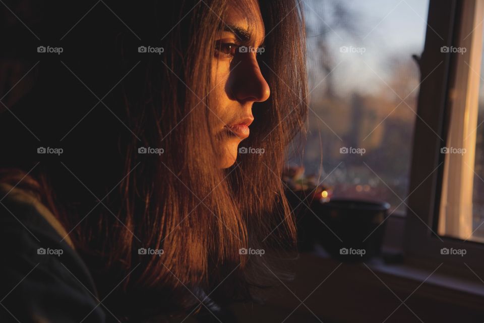 A young woman in bright sun rays