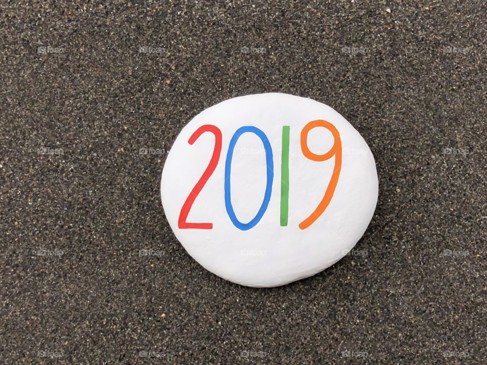 2019 year on a carved and painted stone over black volcanic sand