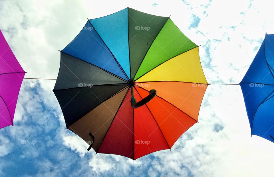 rainbow colors unbrella on the blue sky background