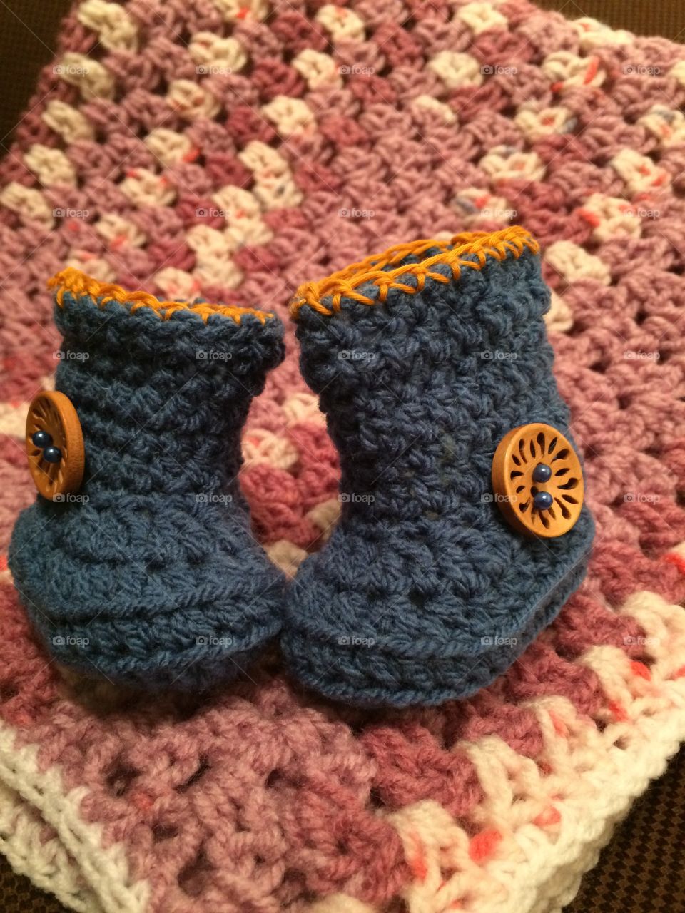Crochet baby booties on blanket