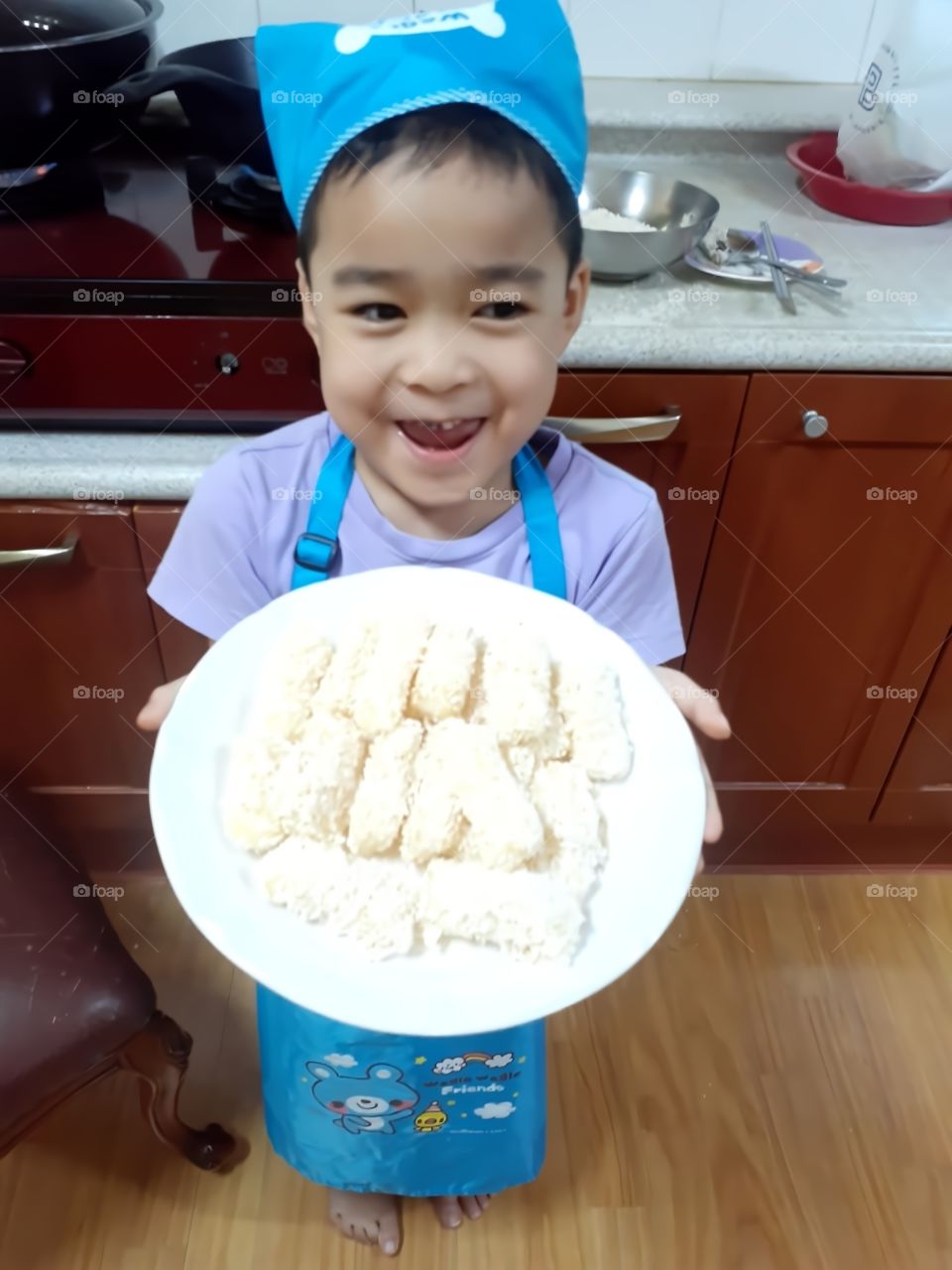 he is so happy watching  the sweet snacks that he cooked.
