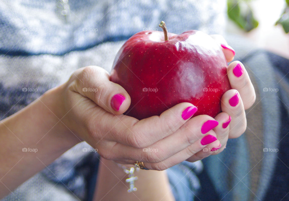 Woman is holding an fresh apple