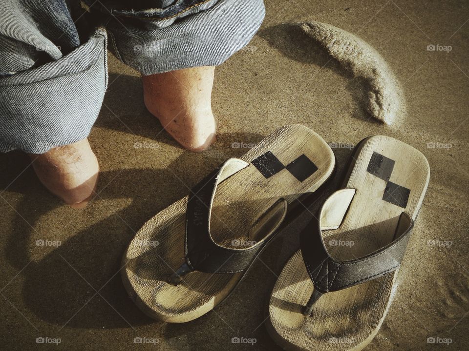 Legs in sand and my sleepers beside 