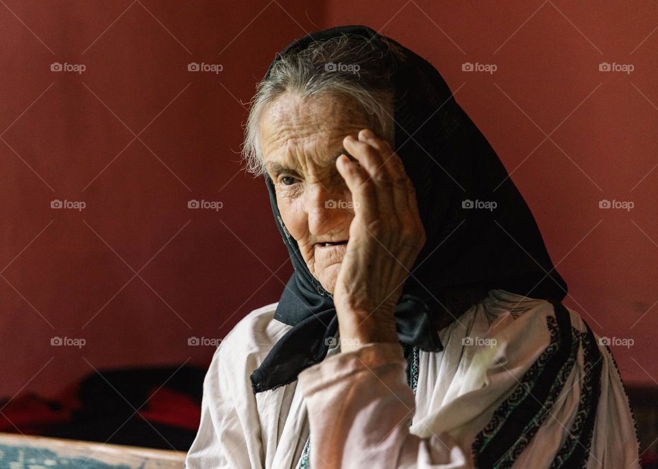 Elderly woman wearing a traditional costume, and talking to people about her life in the countryside.