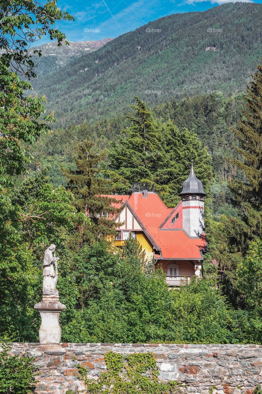 Old house, trees and a sculpture