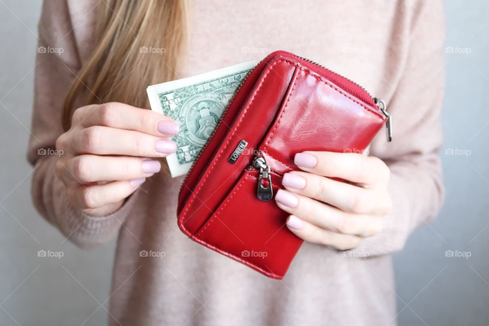 Red color wallet in woman's hands 