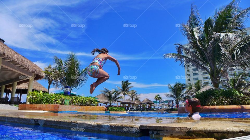 Young girl jumps into beach pool