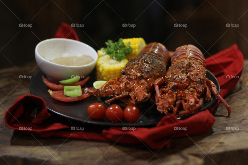 Lobster creamy garlic Lobster served with corn, tomatoes, lemon wedges, cherry and Asian-style creamy garlic sauce.