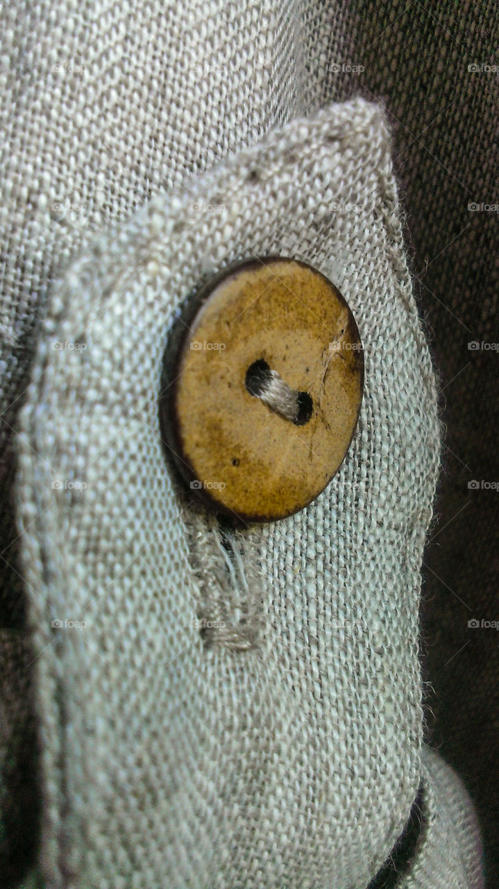 The wooden button to sew to linen fabric
