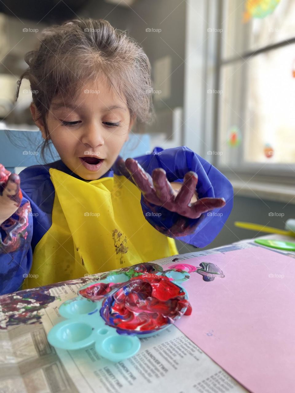 Little girl plays with paint, surprised by paint, little girl makes a mess, toddler girl makes a mess with paint 