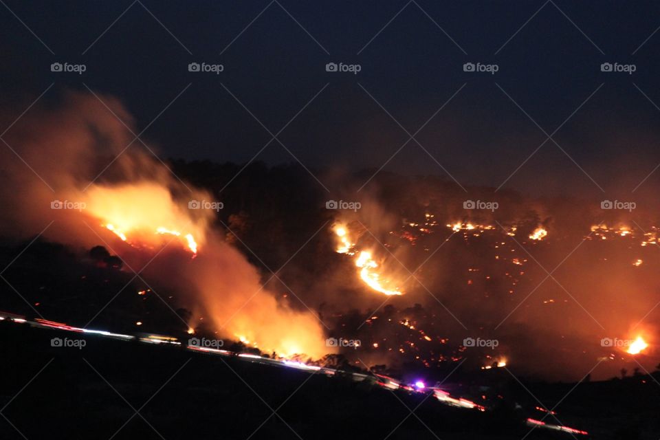 Wildfire on hillside at night