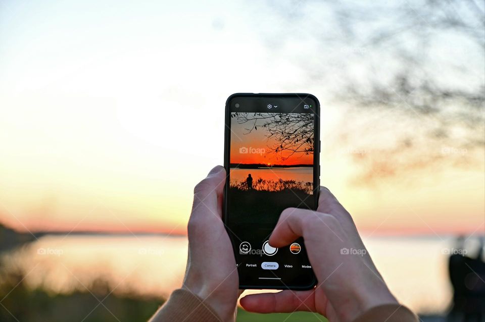 Taking a picture of a person enjoying the sunset