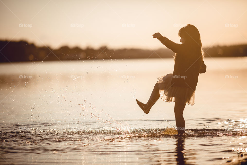 Little girl on lake coast