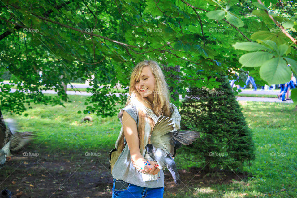 Girl feeding pigeons in the park