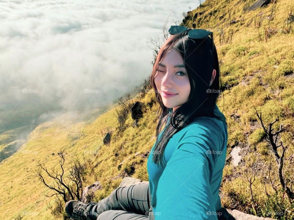 Portrait of a young woman smiling on a beautiful hillside