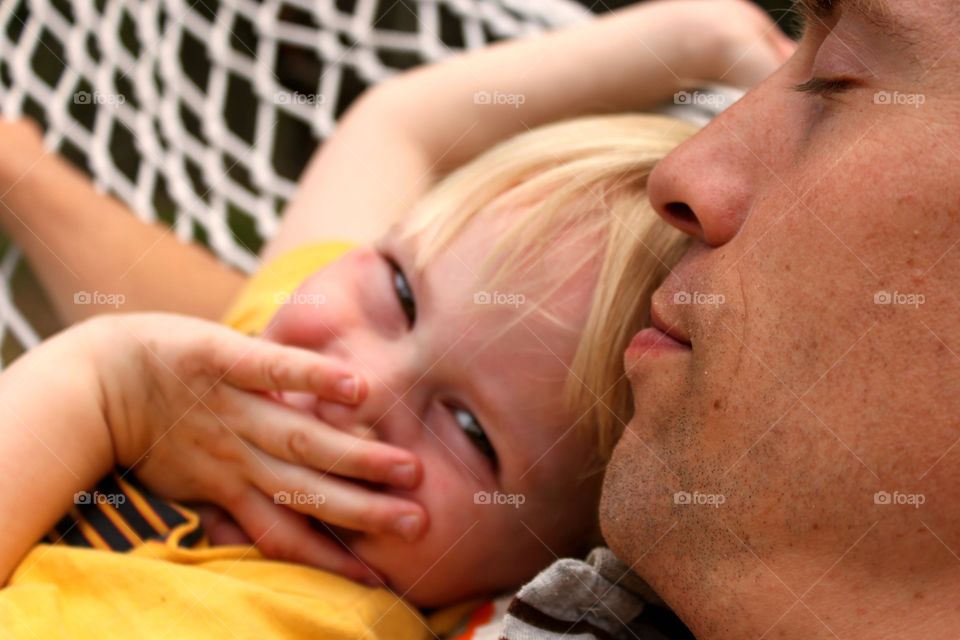 Father and daughter resting on hammock