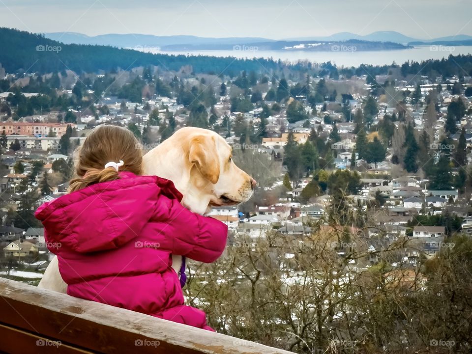 Girl and dog looking down on the City of Victoria, Canada, from Mount Tolmie