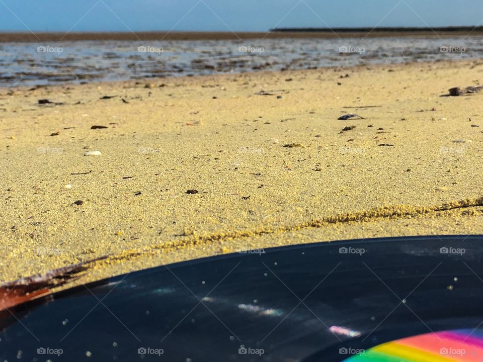 Single vinyl record LP washed ashore on beach in sand low tide 