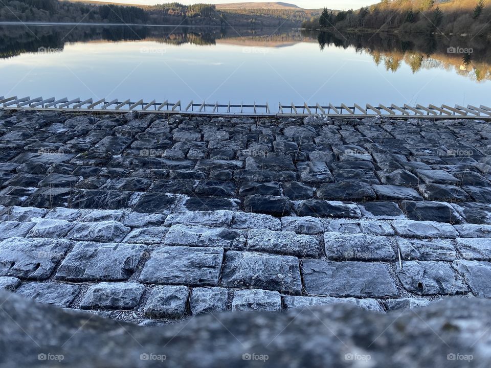 Frozen stones with large body of water and a perfect reflection.