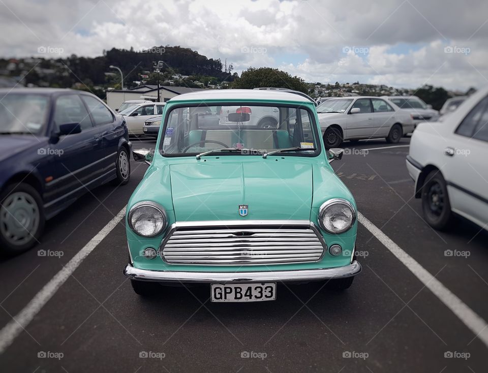 Classic Austin Mini Vintage car parked in car park turquoise colours