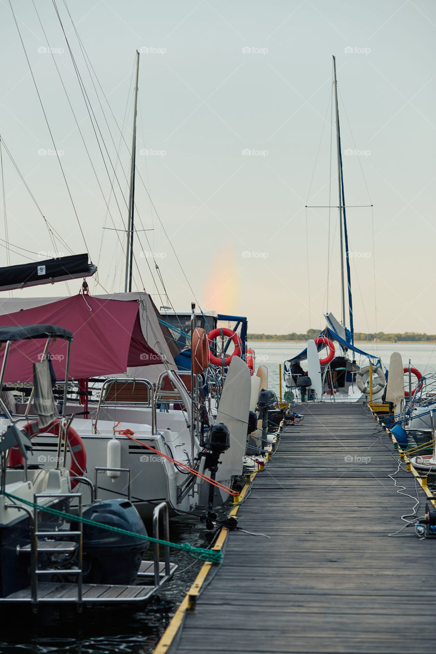 Yachts and boats moored in a harbour at sunrise. Candid people, real moments, authentic situations