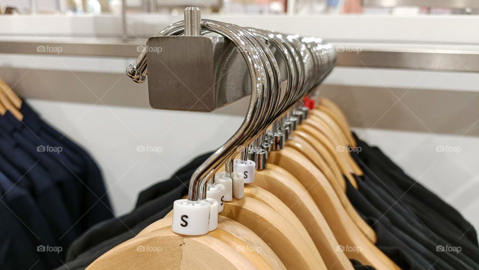 Close up view of hanging clothes arranged on a display rack small size.