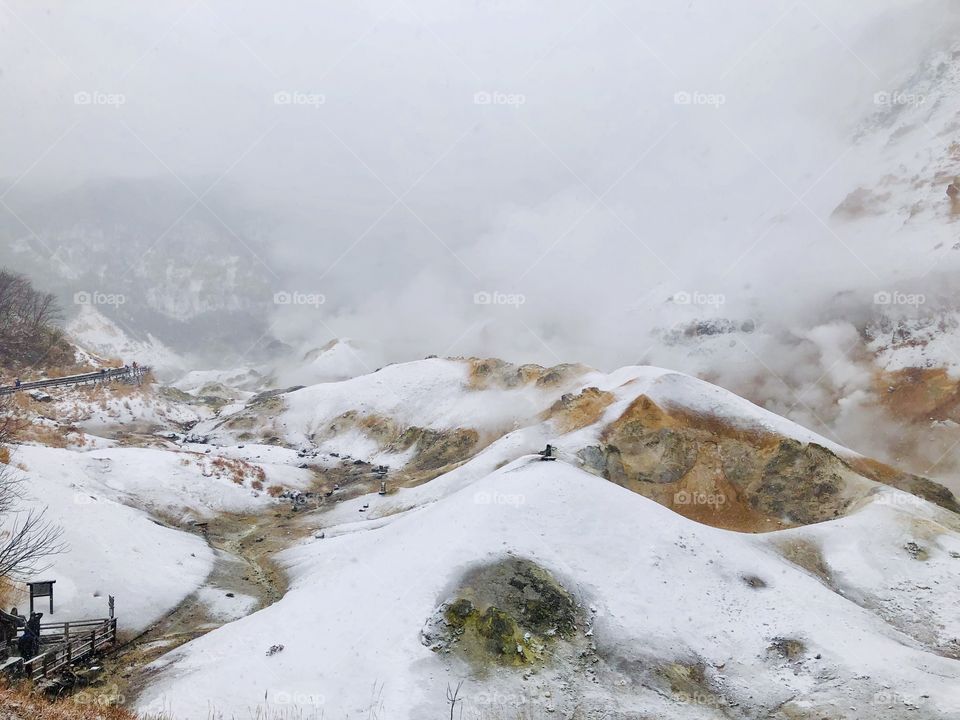 Jigokudani or Hell Valley in the town of Noboribetsu Onsen, hot steam vents, sulfurous streams and other volcanic activity, hot spring waters, Hokkaido, Japan, winter with snow