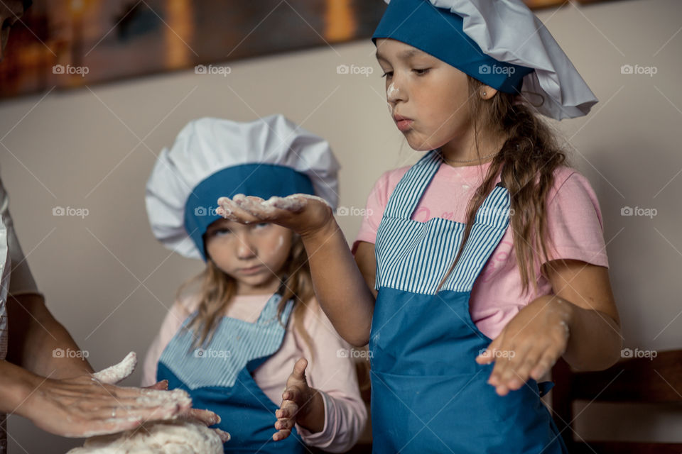 Little sisters cooking the biscuits 