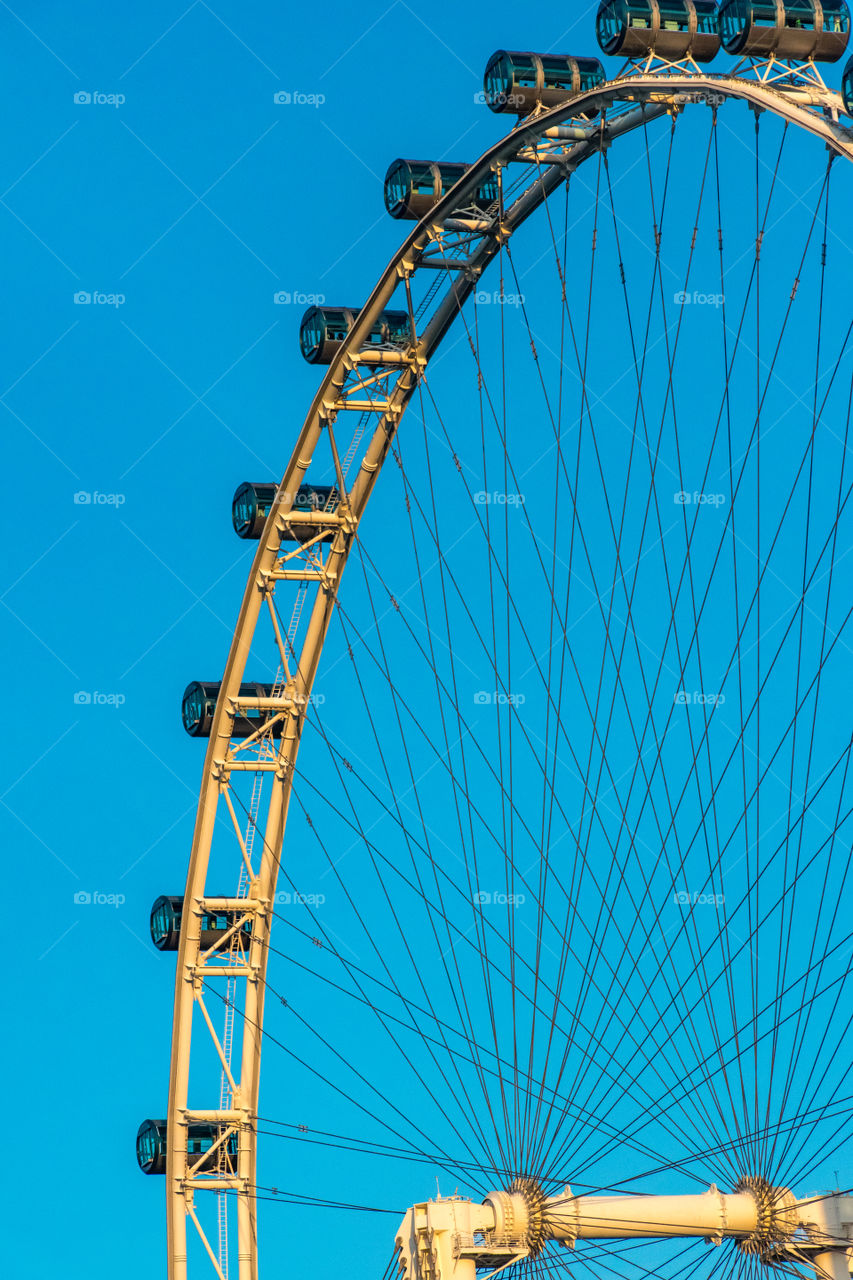 The ferris wheel touched the bright blue sky