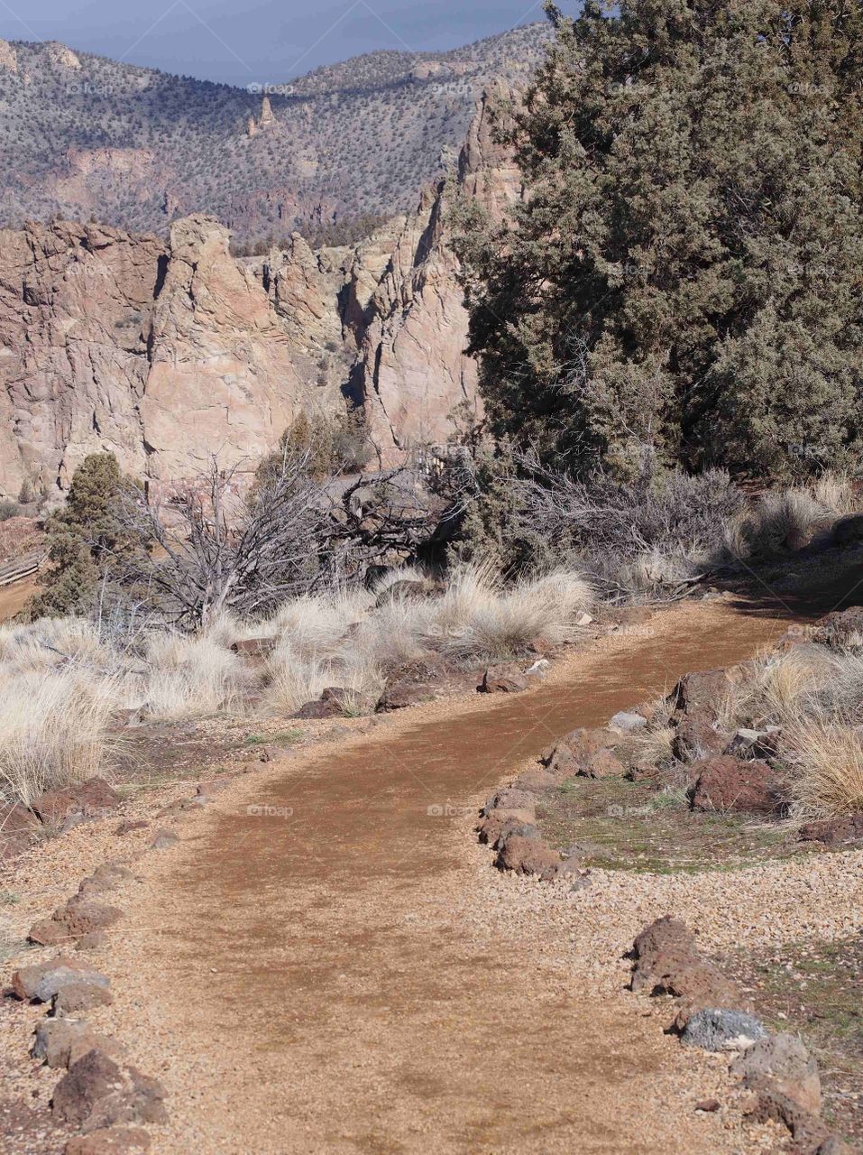 A nice dirt trail bordered with rocks goes through Smith Rock State Park in Central Oregon. 