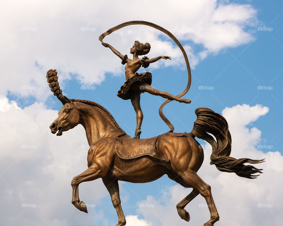 A bronze statue. The acrobat on a horse. Circus