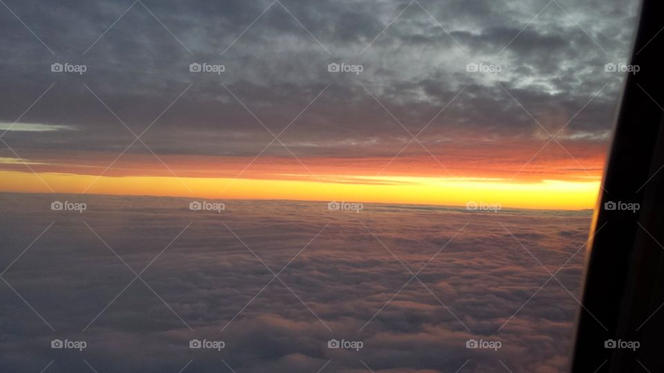 sunset on a plane. above the clouds