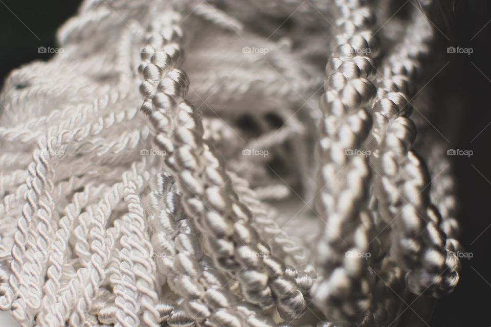 Close up or macro textured shot of white braided rope that has an almost pearl like quality.