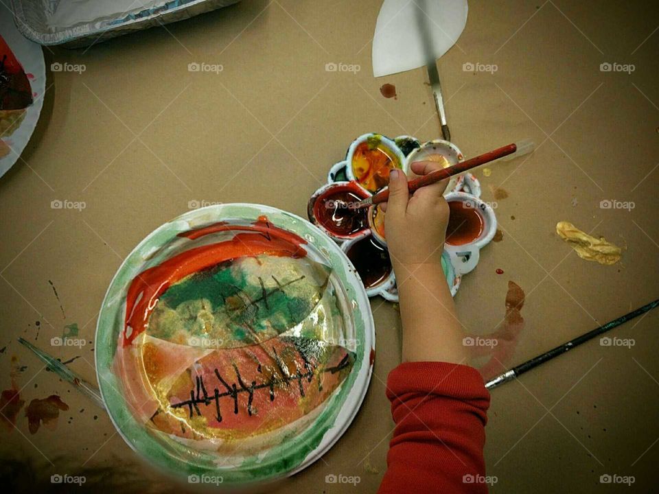 A small child paints her leaves