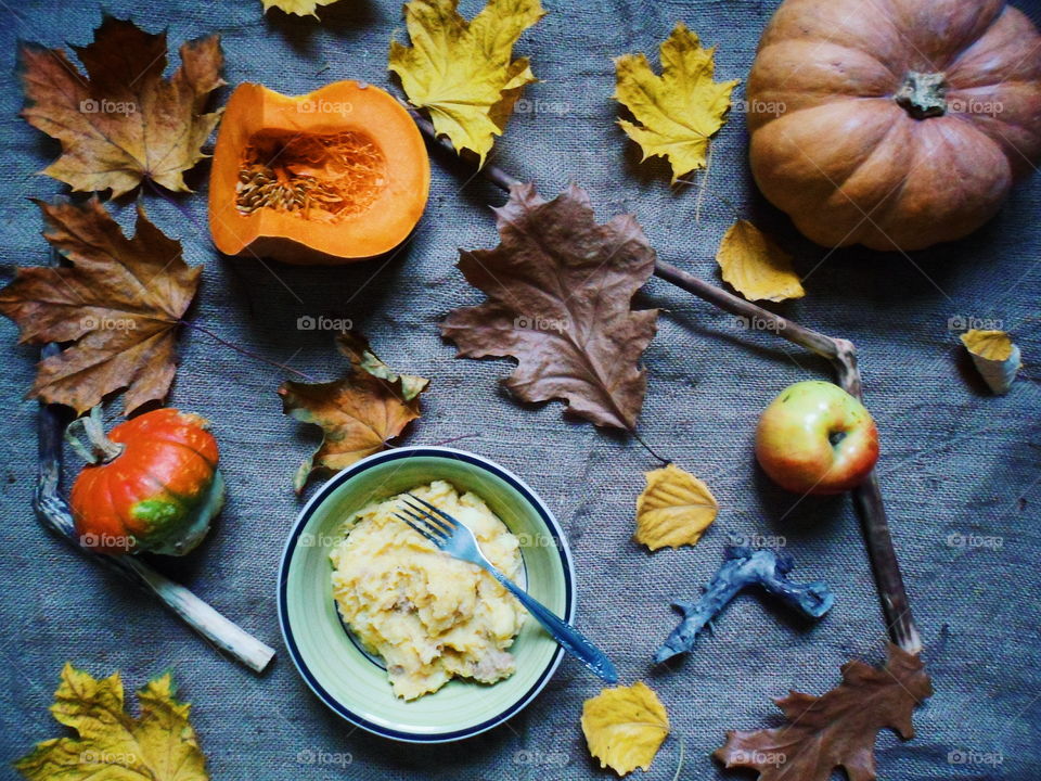 Mashed potatoes in a plate, autumn leaves and pumpkins