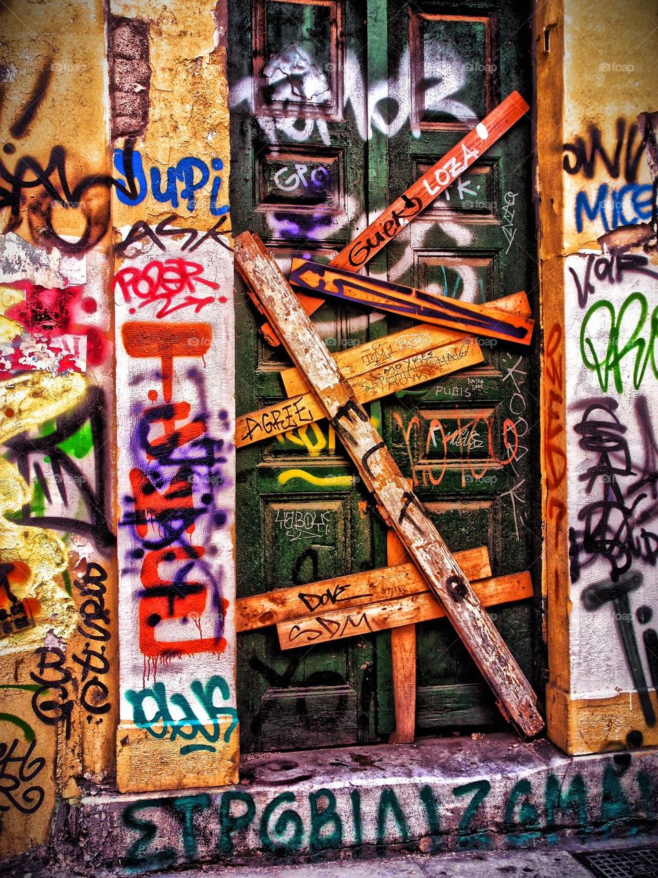Boarded up doorway in Greece, fearful area of town, bad side of town, graffiti and boarded up house, abandoned buildings and properties, emotion of fear portrayed, scared of the the unknown, abandoned building is scary, spooky abandoned building