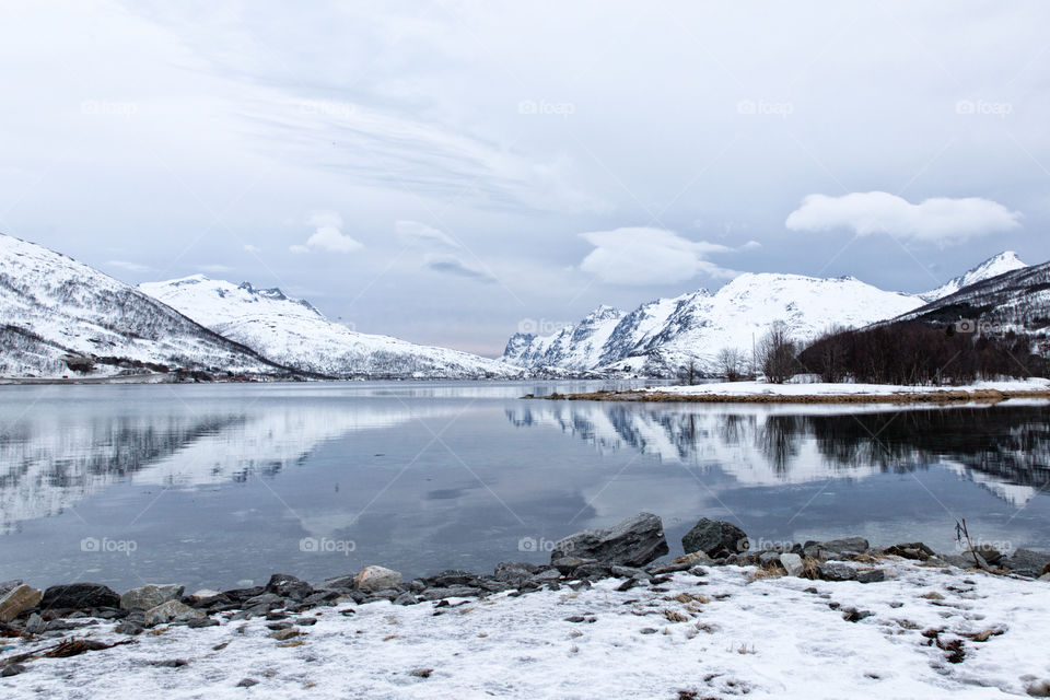 Reflection of snowy mountains against lake