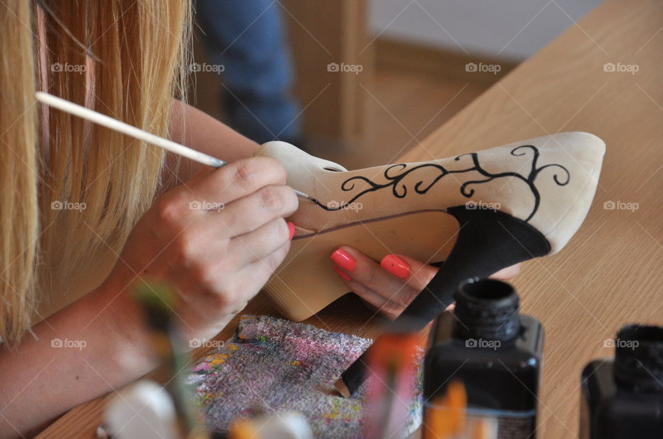 Girl painting on shoe