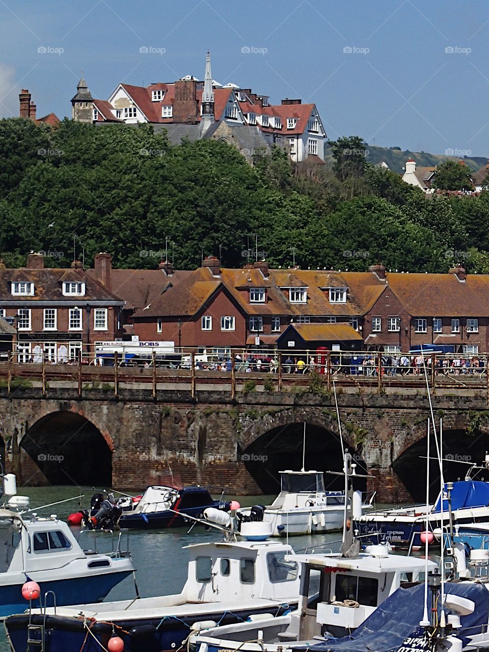 Tourists enjoy a sunny summer day along the bay while on vacation in Folkestone in England 