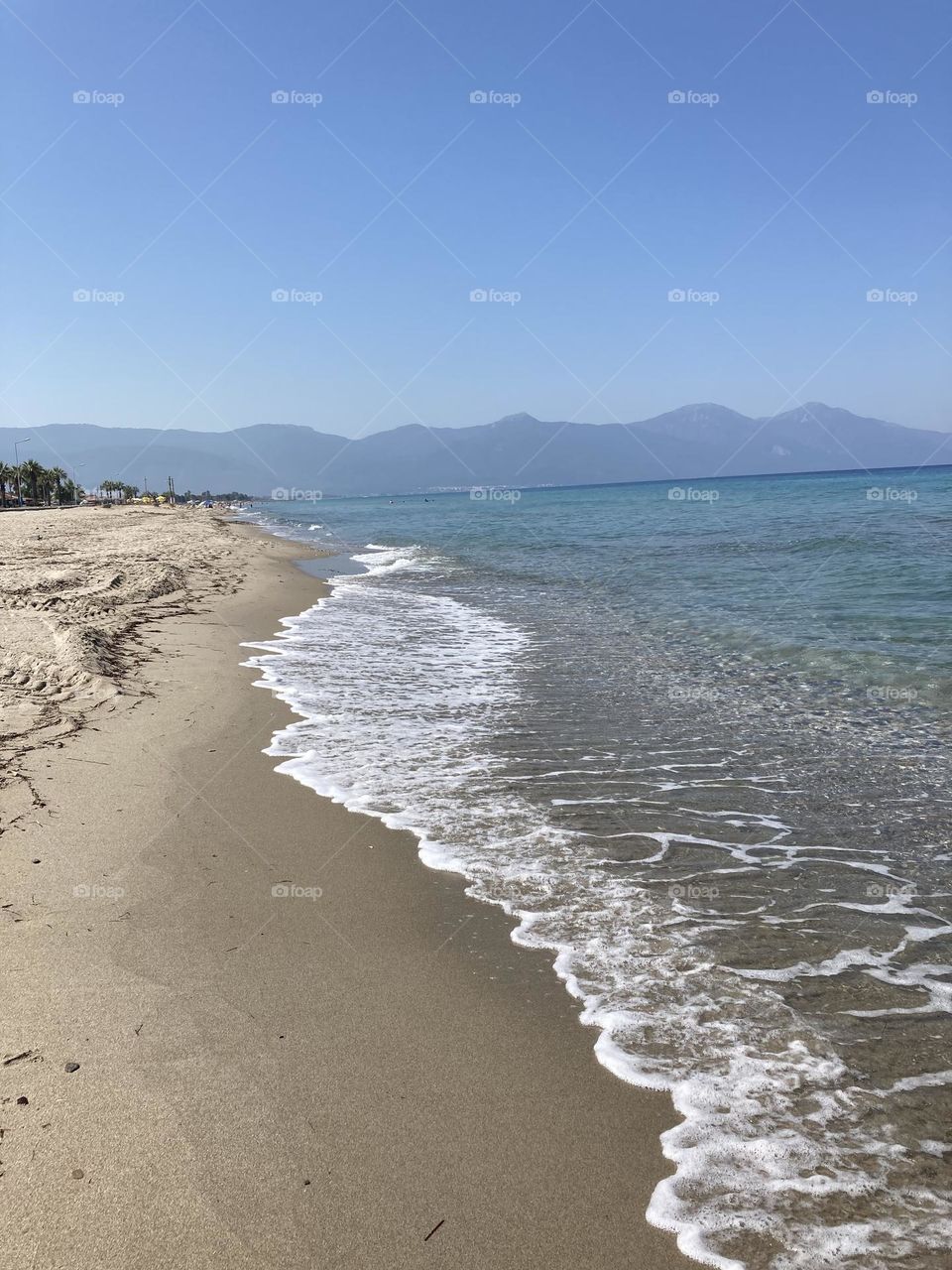 Beach time on holidays. Blue sky and tall palm trees. Sunsets and sunny days. Summertime in Kusadasi. Vacation travel in Turkey . Summer view. Sunny day during vacation 